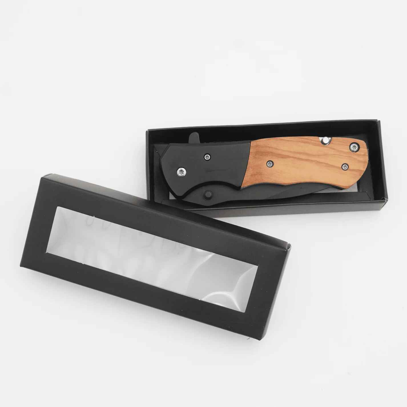 Folding knife with wooden handle in a black box on a white background